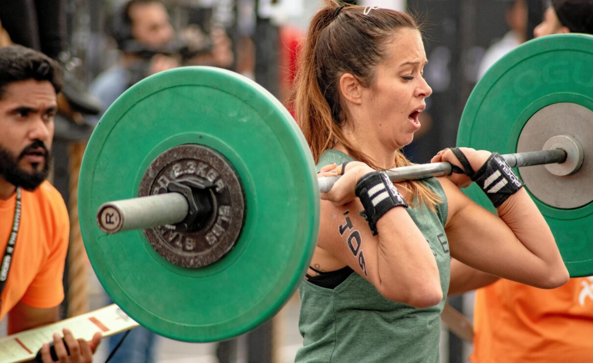 Mujer participando en una competición de Crossfit: ejercicios con barra